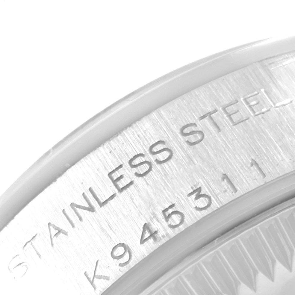 The image shows a close-up of the case back edge of a Rolex Oyster Perpetual 76080 Women
s Stainless Steel Pink Dial 76080 Women
s Stainless Steel Pink Dial watch, highlighting the "STAINLESS STEEL" engraving and serial number.