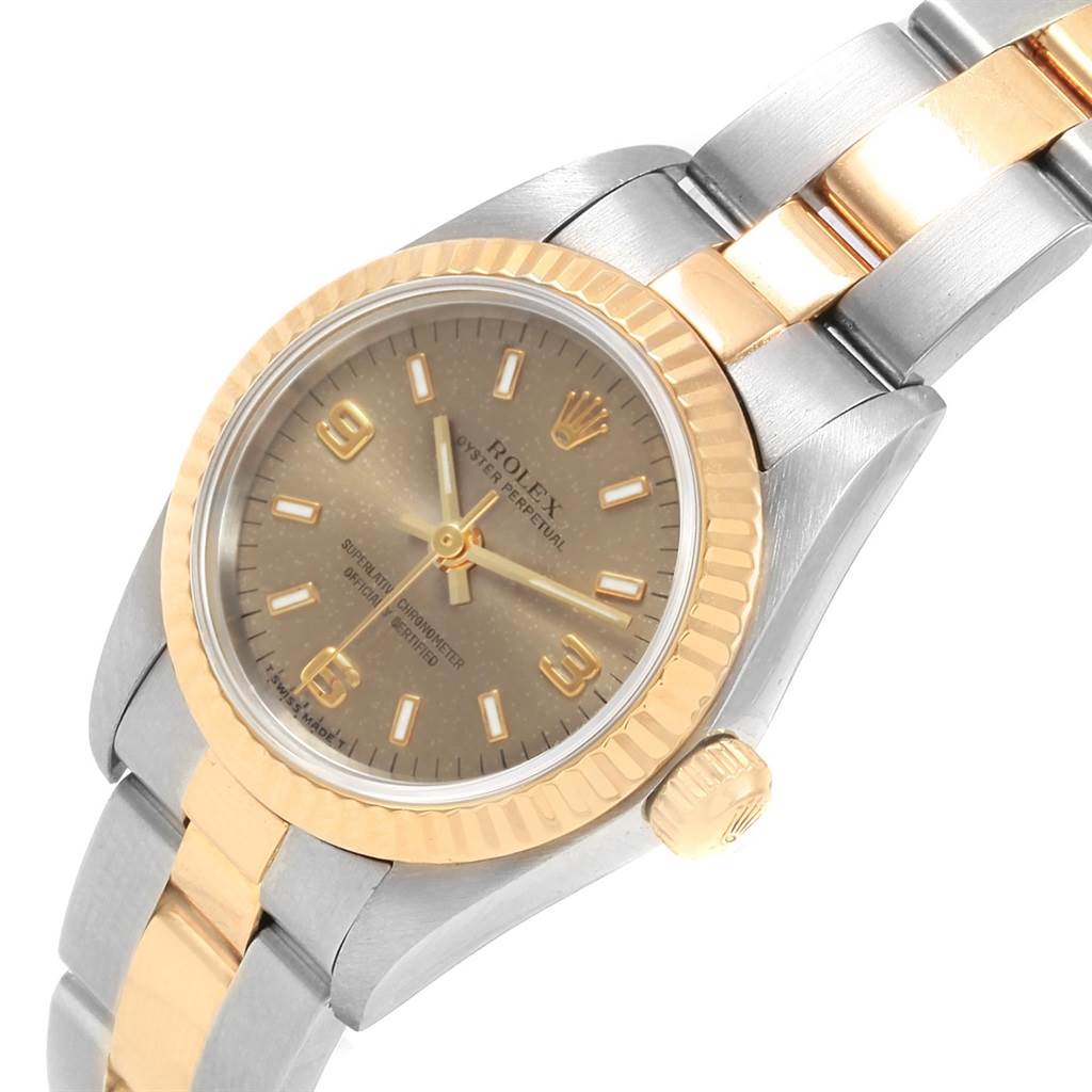 This image shows a close-up view of a Rolex Oyster Perpetual 76193 Women
s Steel and Gold (two tone) Grey Dial 76193 Women
s Steel and Gold (two tone) Grey Dial watch, displaying the face, bezel, crown, and part of the bracelet.