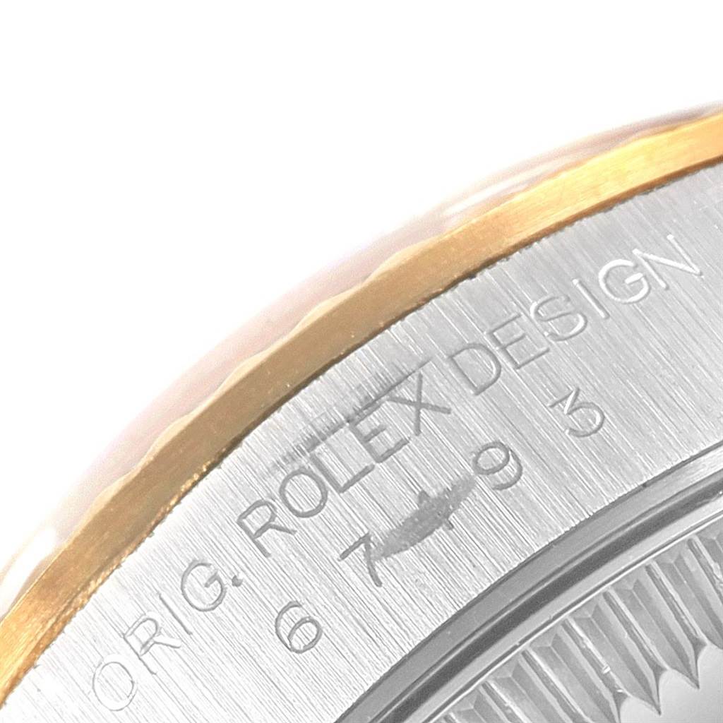 This image shows a close-up of the side of a Rolex Oyster Perpetual 67193 Women
s Steel and Gold (two tone) Champagne Dial 67193 Women
s Steel and Gold (two tone) Champagne Dial watch, highlighting the "ROLEX DESIGN" engraving.