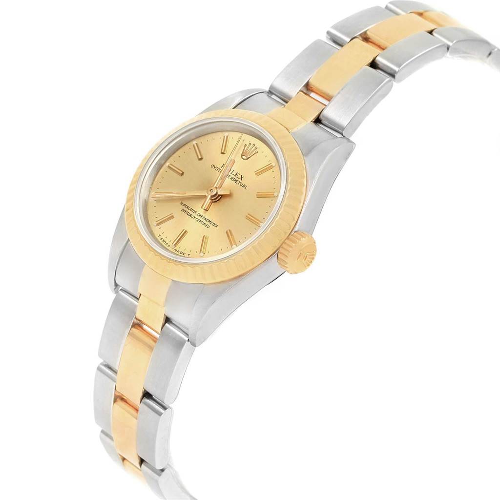 The image shows an angled view of the Rolex Oyster Perpetual 67193 Women
s Steel and Gold (two tone) Champagne Dial 67193 Women
s Steel and Gold (two tone) Champagne Dial watch, highlighting its gold bezel, dial, and two-tone bracelet.