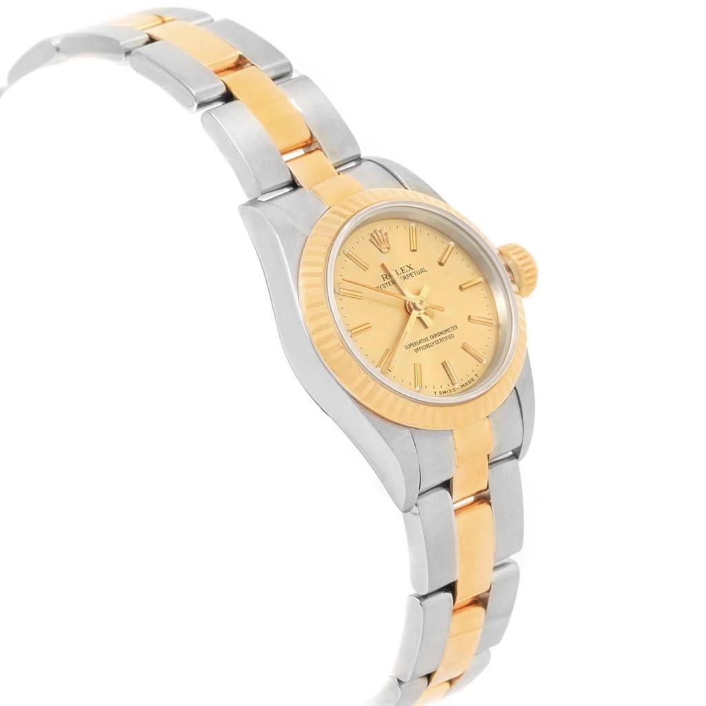 The image shows a side angle of a Rolex Oyster Perpetual 67193 Women
s Steel and Gold (two tone) Champagne Dial 67193 Women
s Steel and Gold (two tone) Champagne Dial watch, highlighting its two-tone bracelet, dial, and fluted bezel.