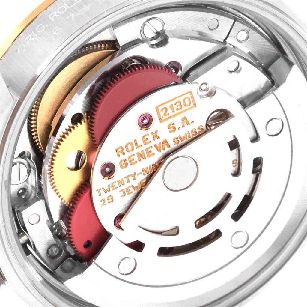 This is a close-up view of the movement inside a Rolex Oyster Perpetual 67193 Women
s Steel and Gold (two tone) Champagne Dial 67193 Women
s Steel and Gold (two tone) Champagne Dial watch, showcasing gears and inscriptions.