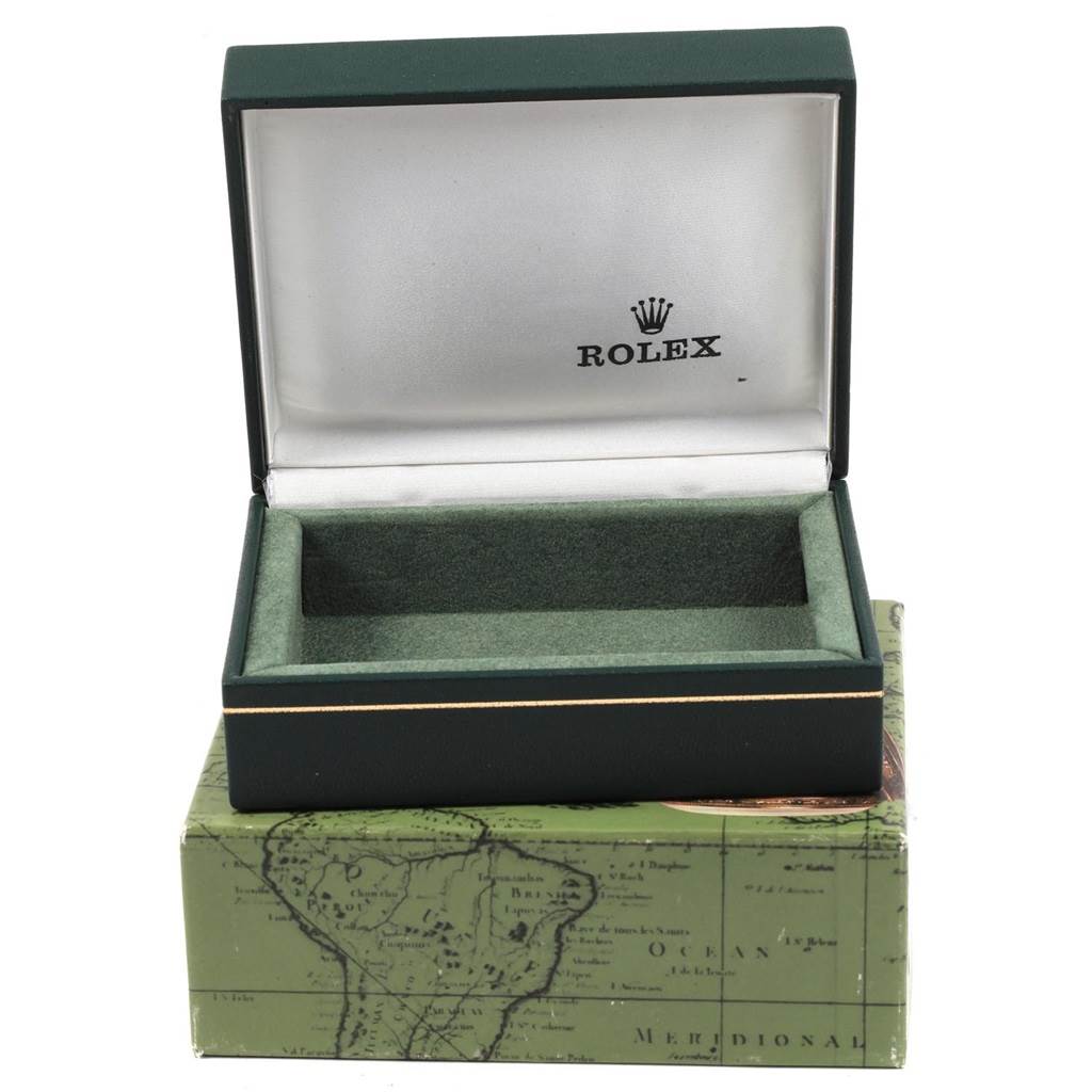 This image shows an open, empty Rolex box for the Oyster Perpetual model, with a green exterior and a map-themed exterior box.
