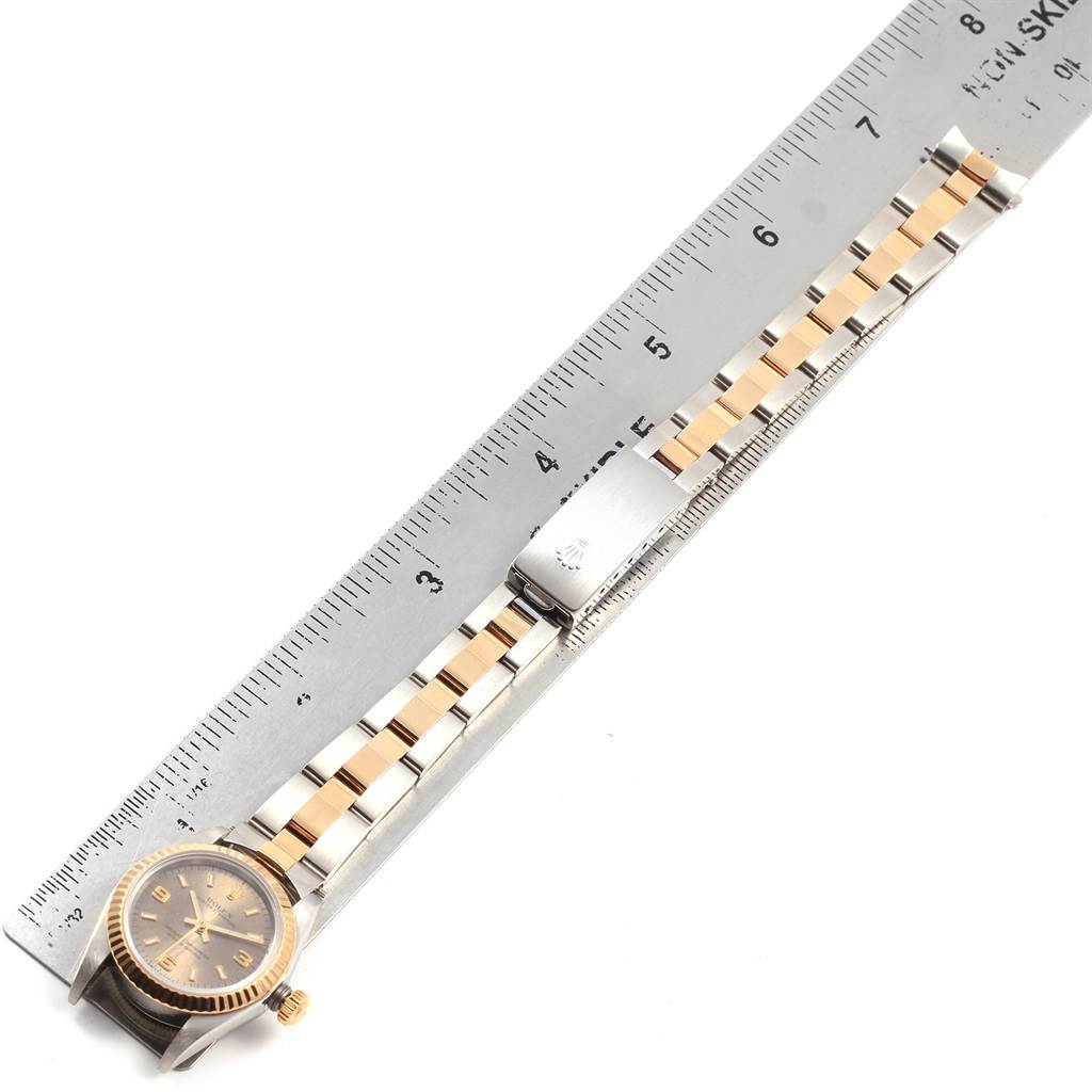 The image shows a Rolex Oyster Perpetual 76193 Women's Steel and Gold (two tone) Grey Dial 76193 Women's Steel and Gold (two tone) Grey Dial watch from an overhead angle, highlighting its dial, bezel, and two-tone bracelet next to a ruler.
