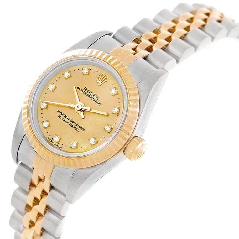 This image shows a Rolex Oyster Perpetual 76193 Women
s Steel and Gold (two tone) Champagne Dial 76193 Women
s Steel and Gold (two tone) Champagne Dial watch from an angled top view, highlighting its gold and silver face and bracelet.