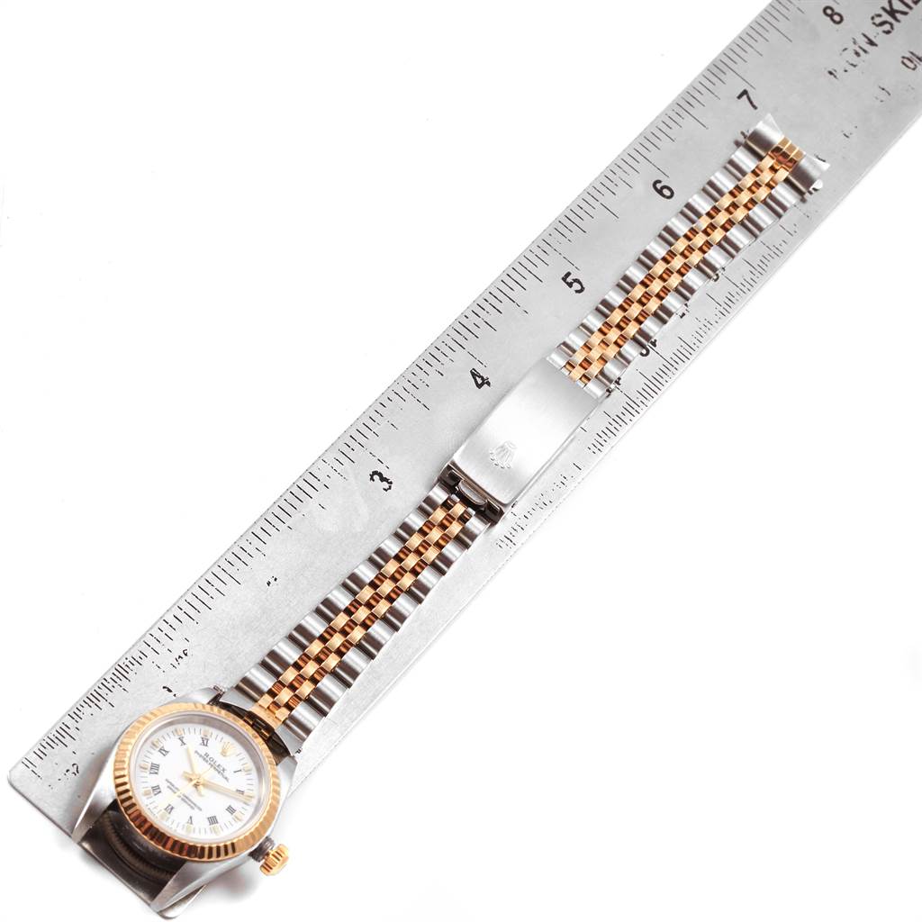 The image shows a Rolex Oyster Perpetual 76193 Women's Steel and Gold (two tone) White Dial 76193 Women's Steel and Gold (two tone) White Dial watch measured against a ruler, displaying its bracelet and clasp.
