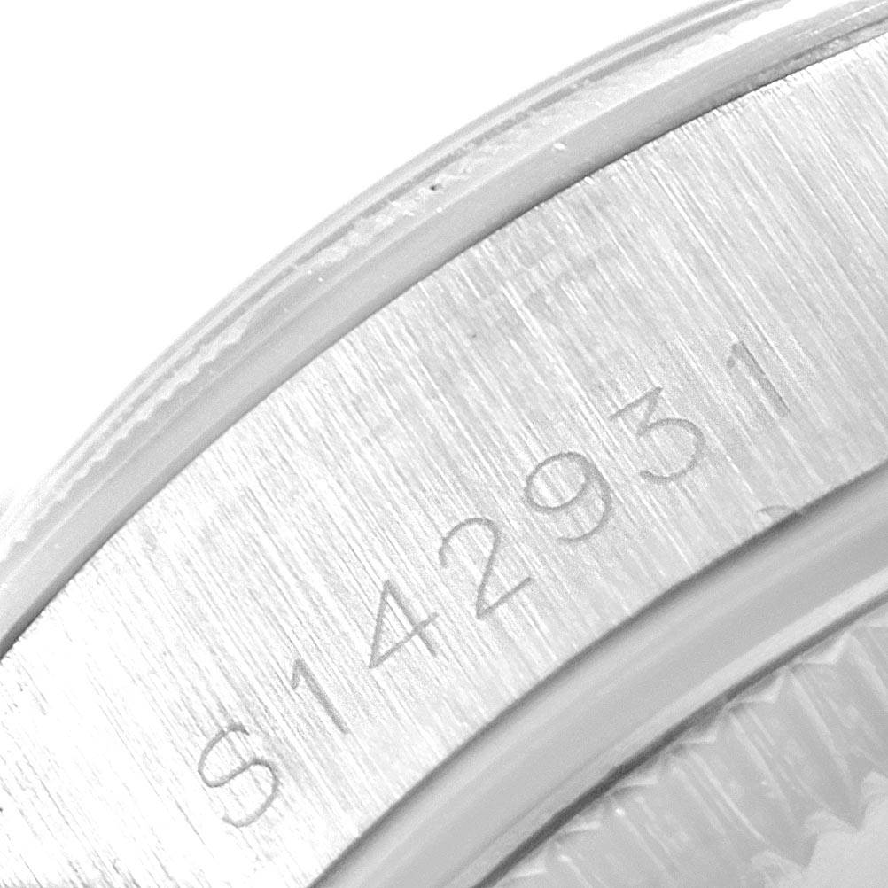 This image shows a close-up of the serial number engraved on the caseback rim of a Rolex Oyster Perpetual 67230 Women
s Stainless Steel Blue Dial 67230 Women
s Stainless Steel Blue Dial watch.