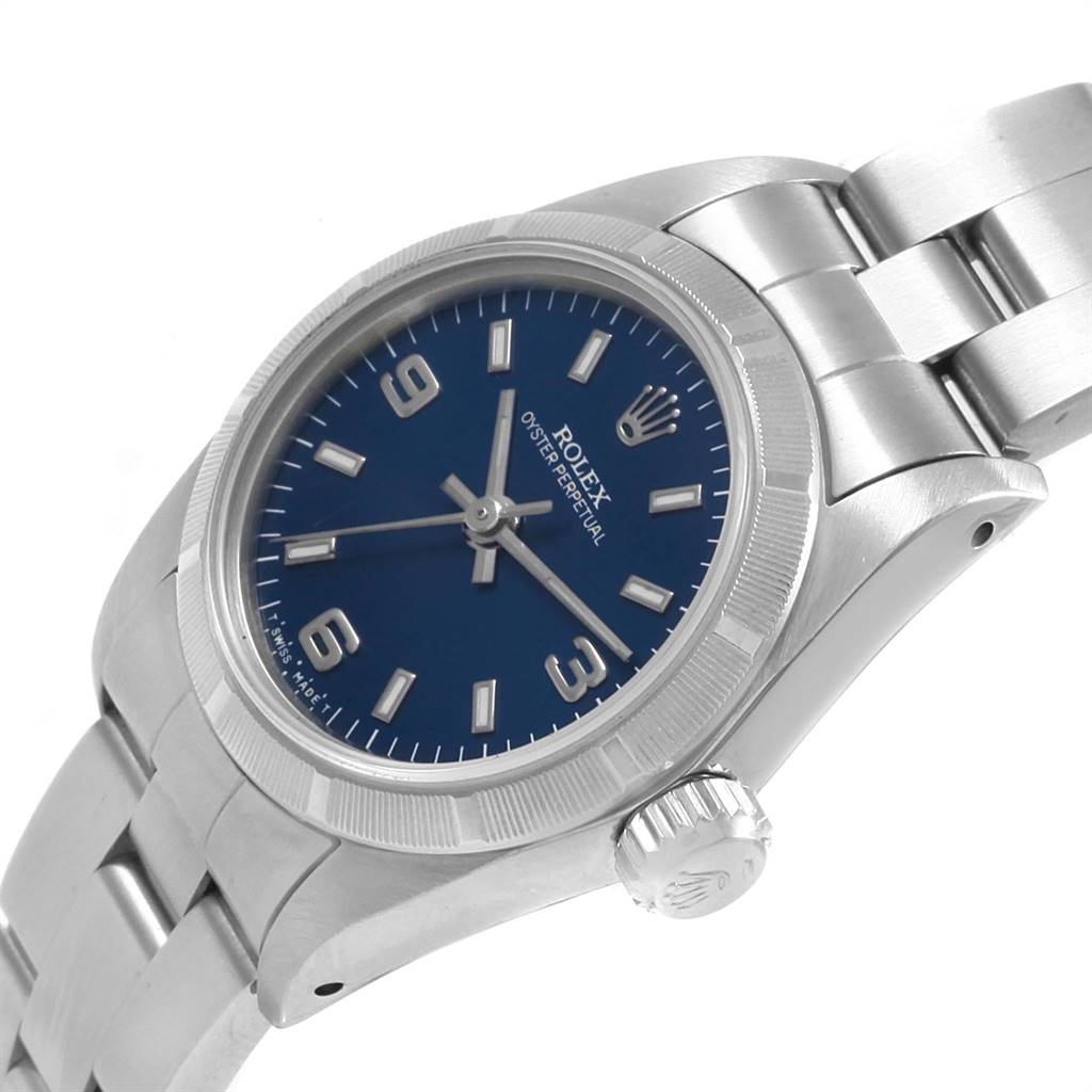 The image shows a close-up side angle of a Rolex Oyster Perpetual 67230 Women
s Stainless Steel Blue Dial 67230 Women
s Stainless Steel Blue Dial watch, highlighting the blue dial, crown, and part of the bracelet.