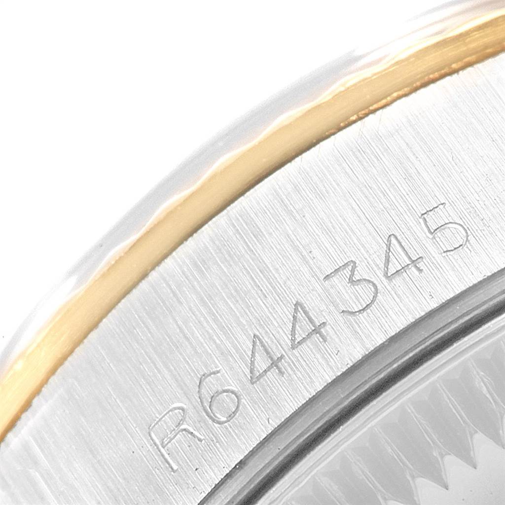 The image shows a close-up of the bezel and casing of the Rolex Oyster Perpetual 67193 Women
s Steel and Gold (two tone) Black Dial 67193 Women
s Steel and Gold (two tone) Black Dial watch, including part of its serial number.