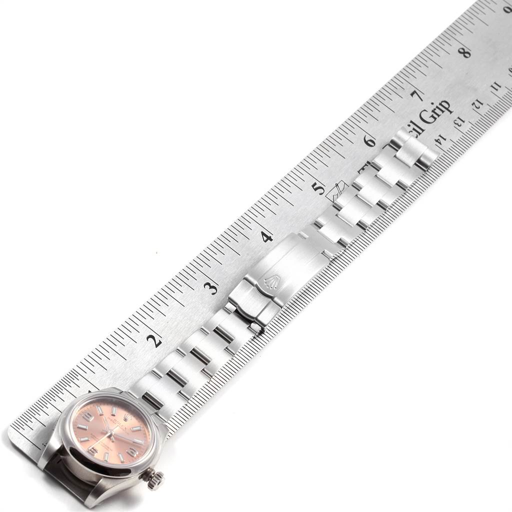 The image shows a side view of a Rolex Oyster Perpetual 176200 Women's Stainless Steel Pink Dial 176200 Women's Stainless Steel Pink Dial watch's case, dial, and partially extended metal bracelet, beside a ruler.