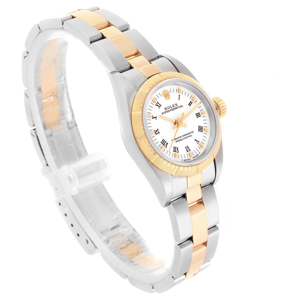 The Rolex Oyster Perpetual 67243 Women
s Steel and Gold (two tone) White Dial 67243 Women
s Steel and Gold (two tone) White Dial watch is shown at an angle, highlighting its two-tone metal strap, bezel, crown, and white dial with Roman numerals.
