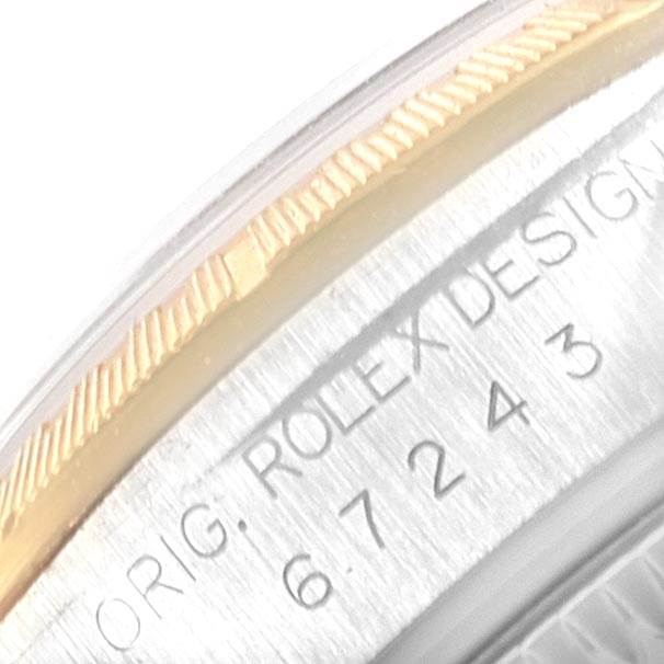 The image shows the engraved model number and part of the bezel on a Rolex Oyster Perpetual 67243 Women
s Steel and Gold (two tone) White Dial 67243 Women
s Steel and Gold (two tone) White Dial watch.