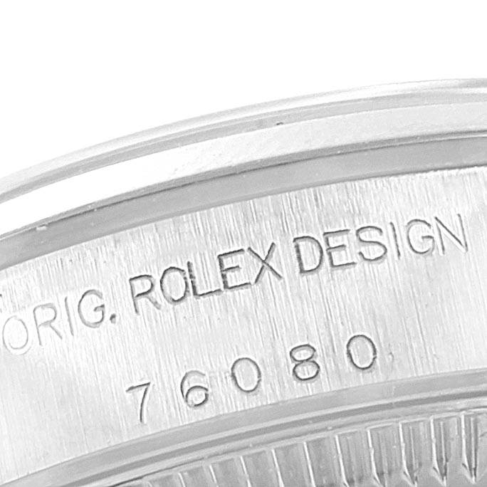 Close-up of the case back of a Rolex Oyster Perpetual 76080 Women
s Stainless Steel Black Dial 76080 Women
s Stainless Steel Black Dial, showing "ROLEX DESIGN" and the model number.