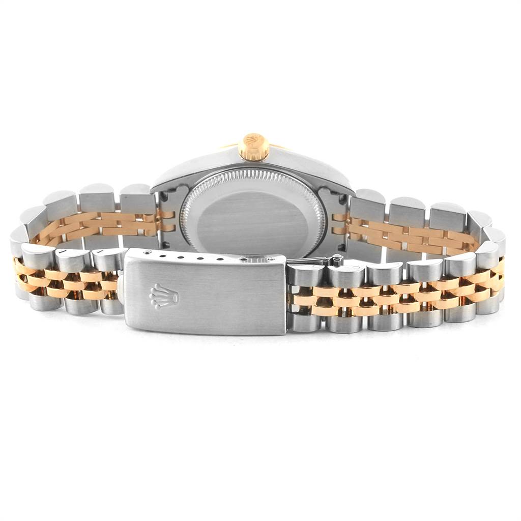 The image shows the back view of a Rolex Oyster Perpetual 76193 Women
s Steel and Gold (two tone) Champagne Dial 76193 Women
s Steel and Gold (two tone) Champagne Dial watch and its two-tone bracelet with the clasp open.