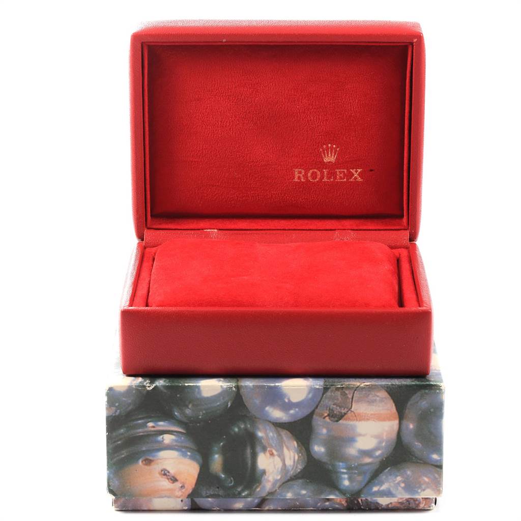 The image shows an open red Rolex watch box for the Oyster Perpetual model, resting on a decorative outer box.