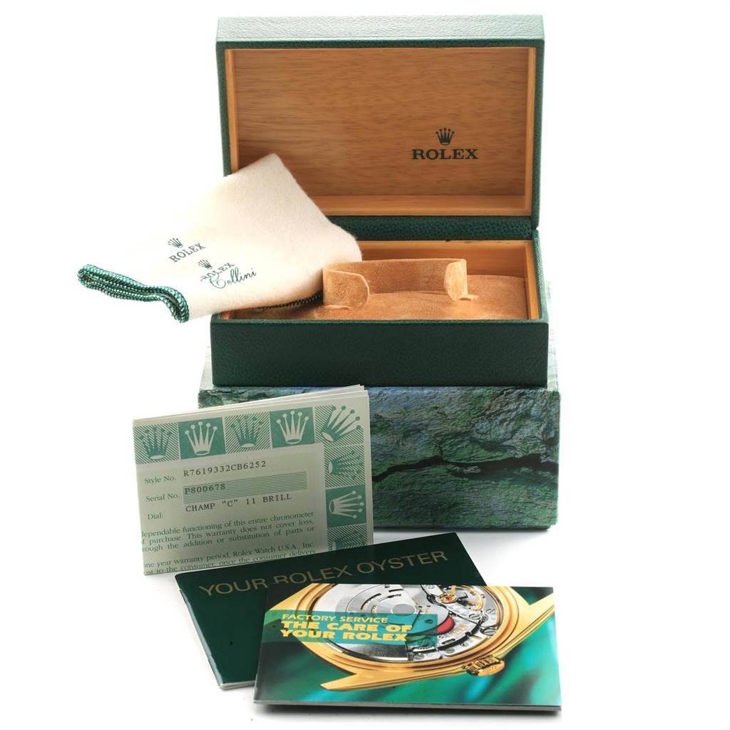 The image shows an open Rolex Oyster Perpetual 76193 Women's Steel and Gold (two tone) Champagne Dial 76193 Women's Steel and Gold (two tone) Champagne Dial box with its accessories, including manuals, a polishing cloth, and warranty cards.