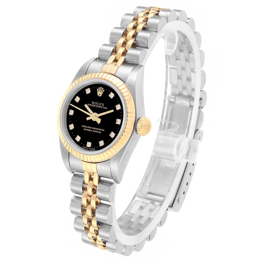 The image shows a Rolex Oyster Perpetual 76193 Women
s Steel and Gold (two tone) Black Dial 76193 Women
s Steel and Gold (two tone) Black Dial watch at a three-quarter angle, highlighting its black dial, gold bezel, and two-tone bracelet.