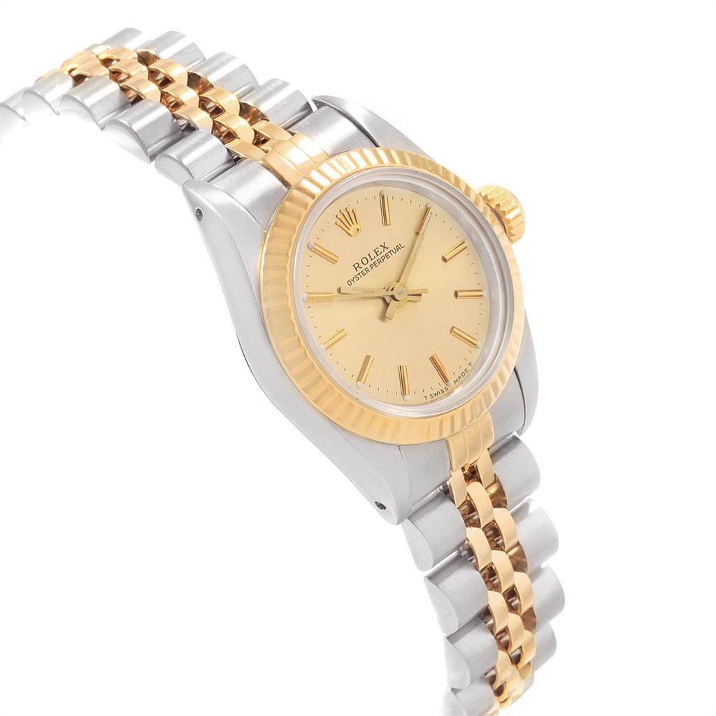 The Rolex Oyster Perpetual 67193 Women's Steel and Gold (two tone) Champagne Dial 67193 Women's Steel and Gold (two tone) Champagne Dial watch is shown at an angle highlighting its gold dial, bezel, and two-tone bracelet.
