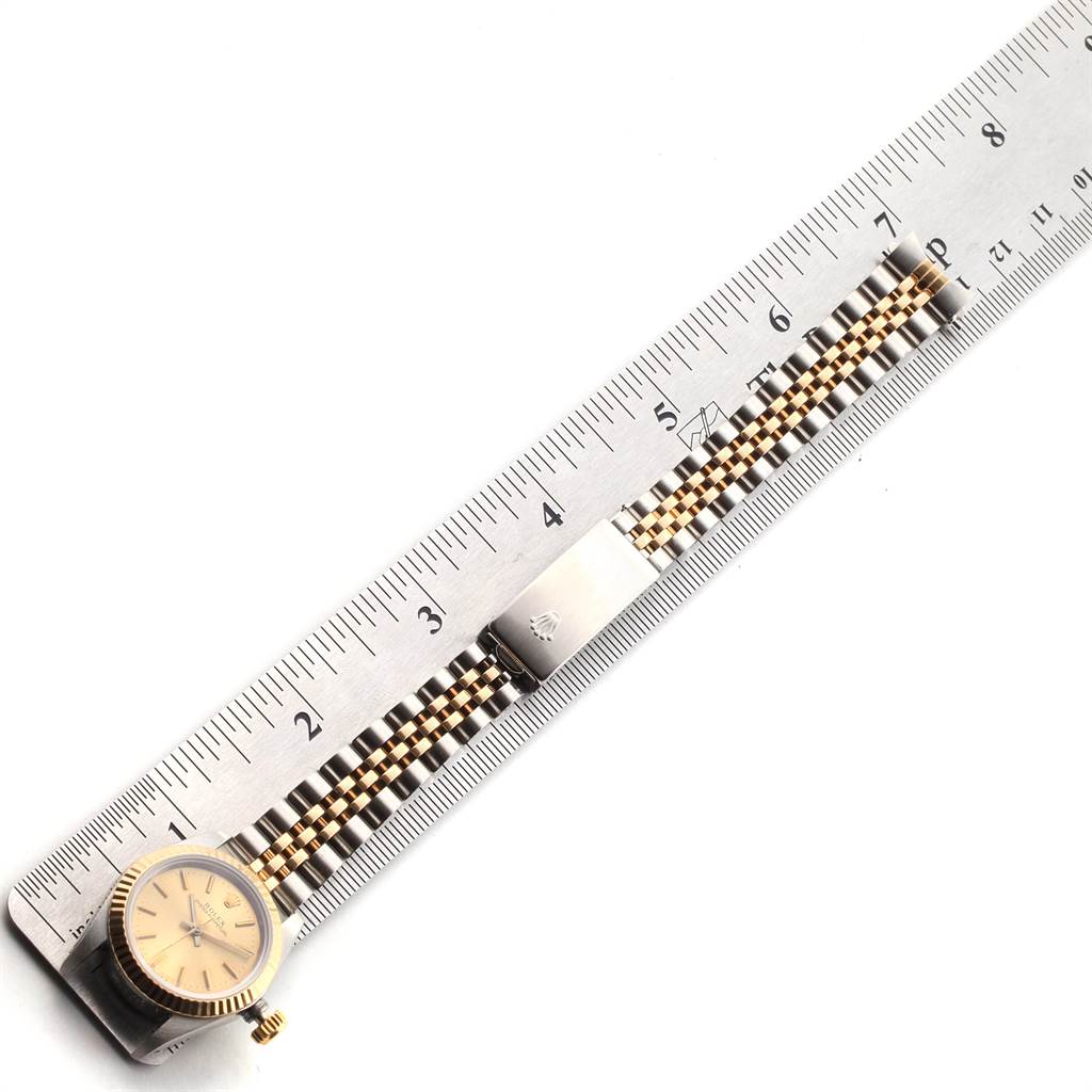 The image shows a top-down view of a Rolex Oyster Perpetual 67193 Women's Steel and Gold (two tone) Champagne Dial 67193 Women's Steel and Gold (two tone) Champagne Dial watch, including its face, bezel, crown, and metal bracelet.