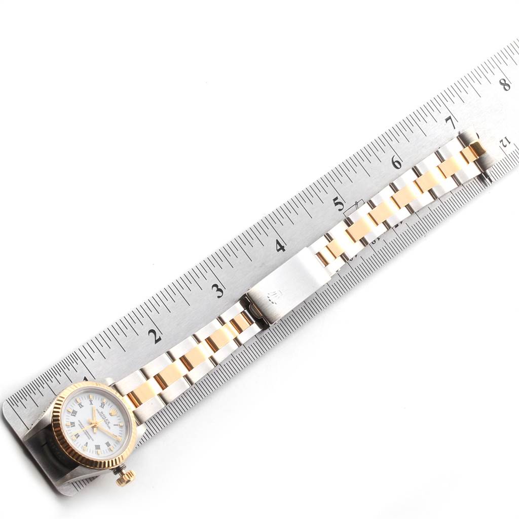 The image shows a Rolex Oyster Perpetual 67193 Women's Steel and Gold (two tone) White Dial 67193 Women's Steel and Gold (two tone) White Dial watch placed alongside a ruler, showcasing its dial, crown, and bracelet.