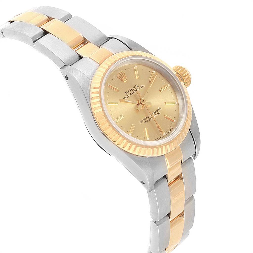 The Rolex Oyster Perpetual 67193 Women's Steel and Gold (two tone) Champagne Dial 67193 Women's Steel and Gold (two tone) Champagne Dial watch is angled to show the gold and silver band, fluted bezel, and champagne dial.
