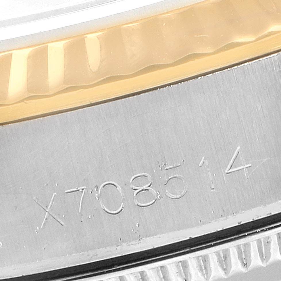 This close-up image shows the engraved serial number and part of the bezel on a Rolex Oyster Perpetual 67193 Women's Steel and Gold (two tone) Blue Dial 67193 Women's Steel and Gold (two tone) Blue Dial watch.