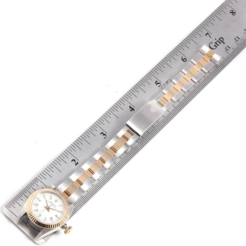 The image shows a Rolex Oyster Perpetual 67193 Women's Steel and Gold (two tone) White Dial 67193 Women's Steel and Gold (two tone) White Dial watch laid flat alongside a ruler, highlighting the bracelet and watch head.