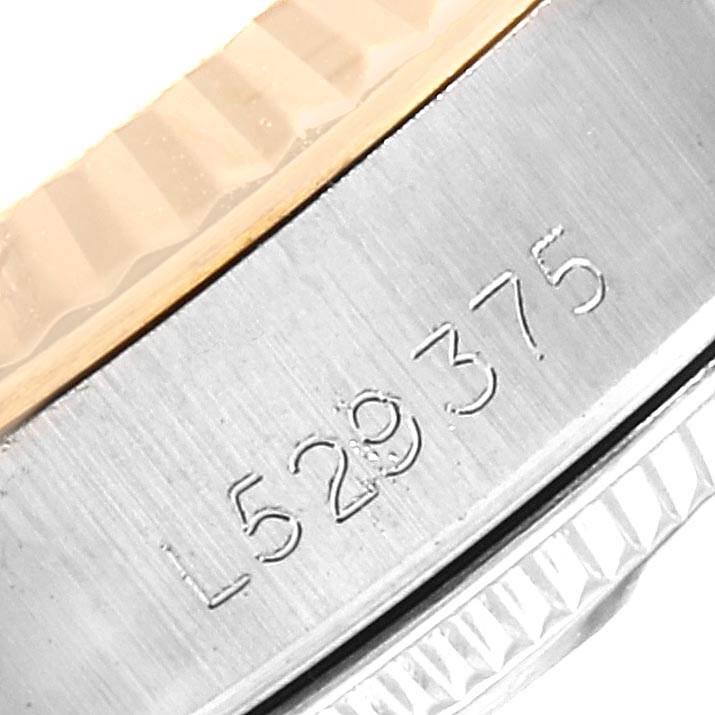 This image shows a close-up of the serial number engraved on the side of the bezel of a Rolex Oyster Perpetual 67193 Women's Steel and Gold (two tone) White Dial 67193 Women's Steel and Gold (two tone) White Dial watch.