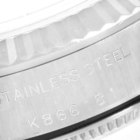 This close-up shows the stainless steel casing and the engraved serial number on the bezel of a Rolex Oyster Perpetual 76094 Women's Stainless Steel Black Dial 76094 Women's Stainless Steel Black Dial watch.