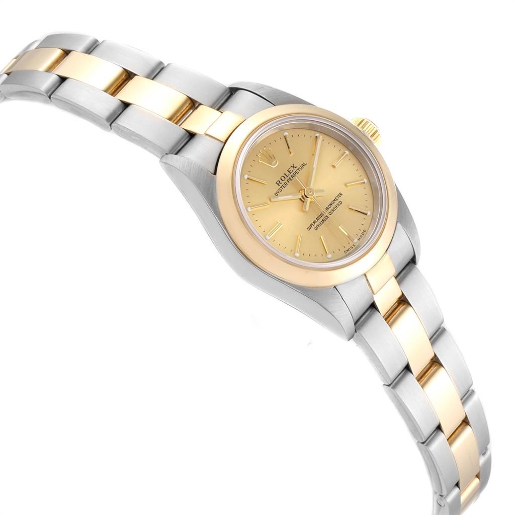 The image shows a Rolex Oyster Perpetual 76183 Women
s Steel and Gold (two tone) Champagne Dial 76183 Women
s Steel and Gold (two tone) Champagne Dial watch angled to display its gold and silver bracelet, dial, and crown.