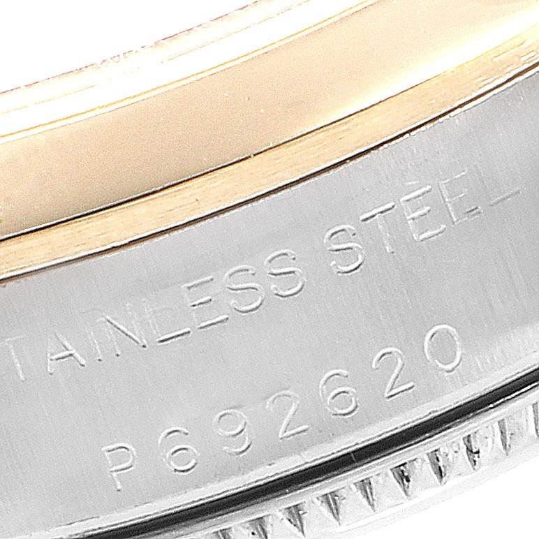 The image shows a close-up of the side of a Rolex Oyster Perpetual 76183 Women
s Steel and Gold (two tone) Champagne Dial 76183 Women
s Steel and Gold (two tone) Champagne Dial watch, highlighting the engraved stainless steel marking and part of the bezel.