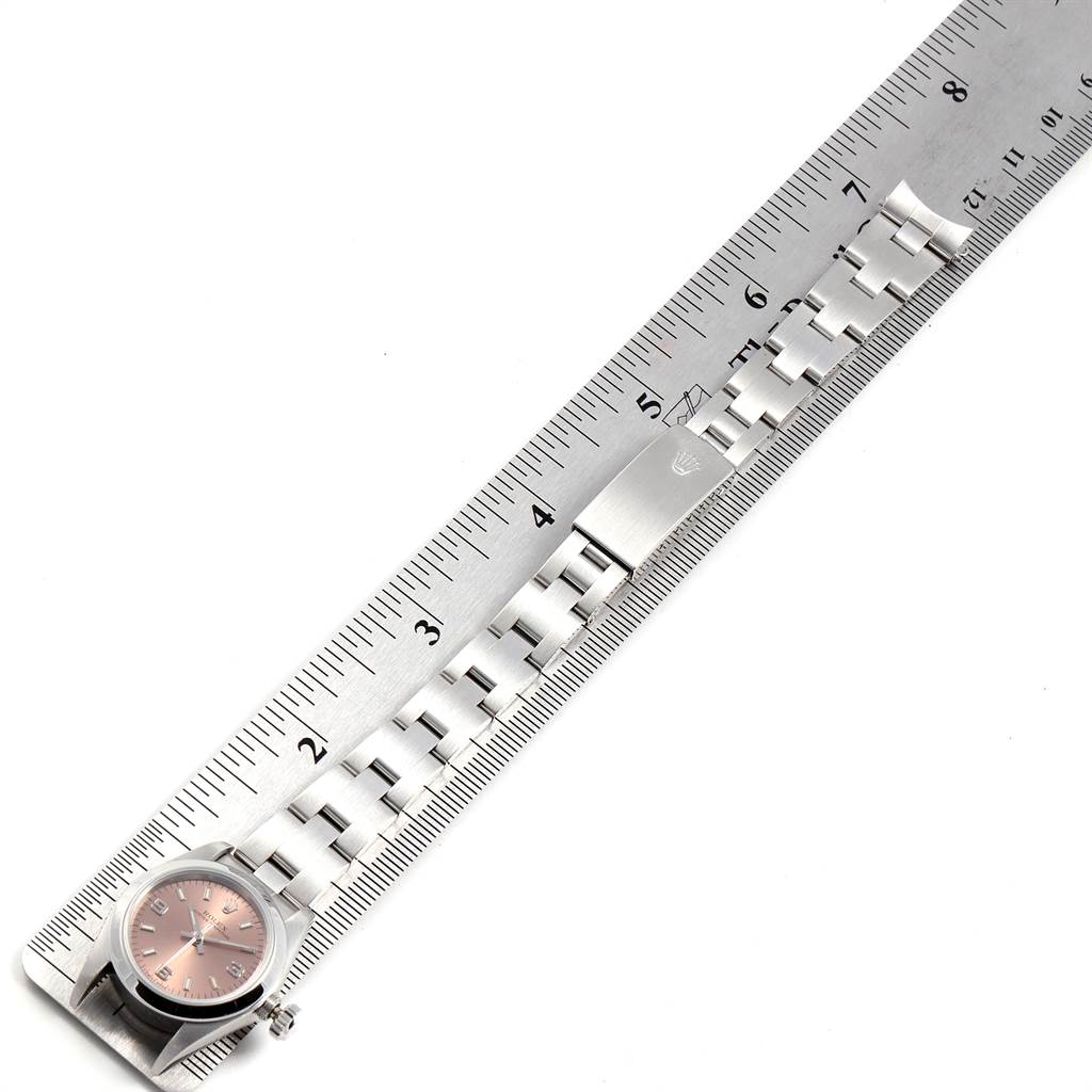 The image shows a Rolex Oyster Perpetual 67180 Women's Stainless Steel Pink Dial 67180 Women's Stainless Steel Pink Dial watch face and band laid flat against a ruler for measurement.