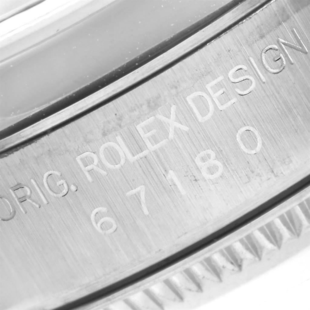 This close-up image shows the engraved text on the bezel of a Rolex Oyster Perpetual 67180 Women's Stainless Steel Pink Dial 67180 Women's Stainless Steel Pink Dial watch.