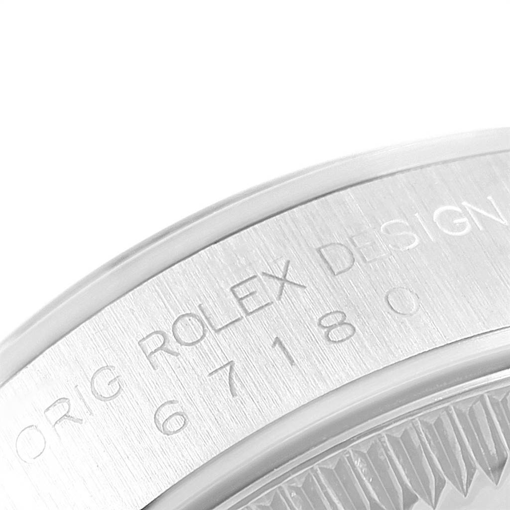 This image shows a close-up of the side of the Rolex Oyster Perpetual 67180 Women's Stainless Steel Blue Dial 67180 Women's Stainless Steel Blue Dial watch, highlighting the engraved markings.