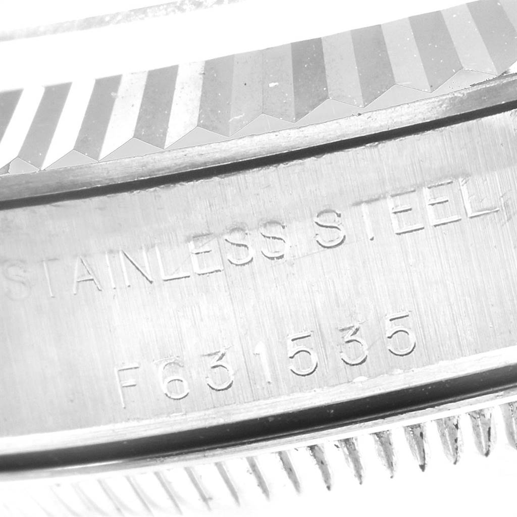 This close-up image shows the engraved stainless steel case and fluted bezel of the Rolex Oyster Perpetual 76094 Women's Stainless Steel Black Dial 76094 Women's Stainless Steel Black Dial watch.