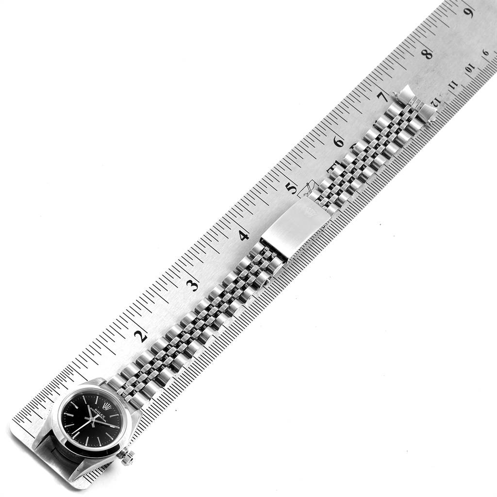 The image shows a Rolex Oyster Perpetual 76080 Women's Stainless Steel Black Dial 76080 Women's Stainless Steel Black Dial watch and its bracelet, measured next to a ruler for size reference.