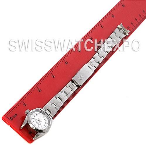 The image shows a Rolex Oyster Perpetual 76080 Women's Stainless Steel White Dial 76080 Women's Stainless Steel White Dial watch laid flat with its stainless steel bracelet on a red ruler.