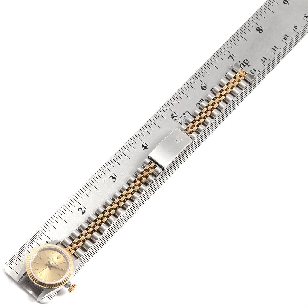 This image shows a top view of a Rolex Oyster Perpetual 67193 Women's Steel and Gold (two tone) Champagne Dial 67193 Women's Steel and Gold (two tone) Champagne Dial watch placed alongside a ruler, displaying the watch face and bracelet.