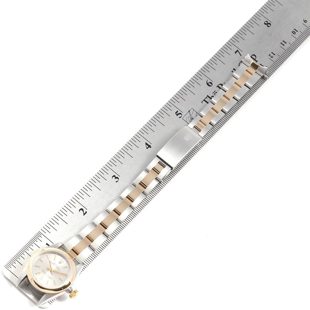 This image shows the Rolex Oyster Perpetual 67183 Women's Steel and Gold (two tone) Silver Dial 67183 Women's Steel and Gold (two tone) Silver Dial watch laid flat alongside a ruler, displaying the bracelet and watch face.