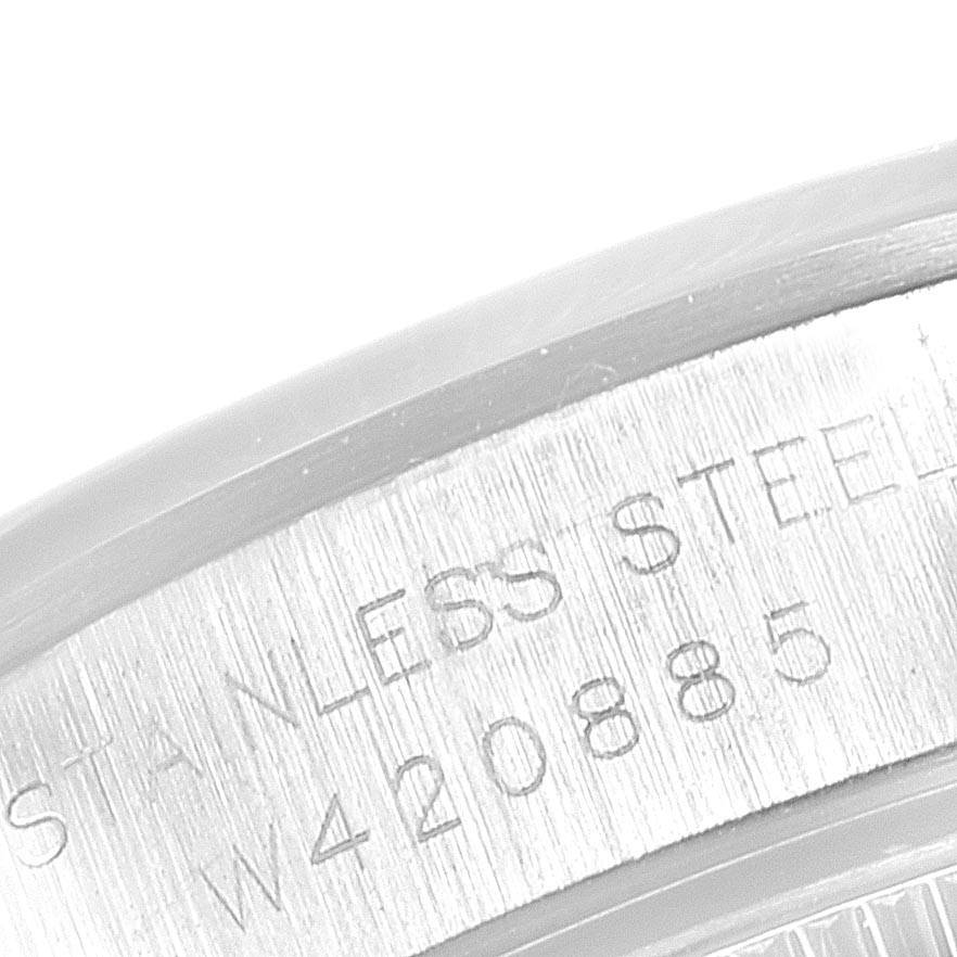 This image shows a close-up of the side edge of a Rolex Oyster Perpetual 67183 Women's Steel and Gold (two tone) Silver Dial 67183 Women's Steel and Gold (two tone) Silver Dial watch with the inscription "STAINLESS STEEL" and serial number.