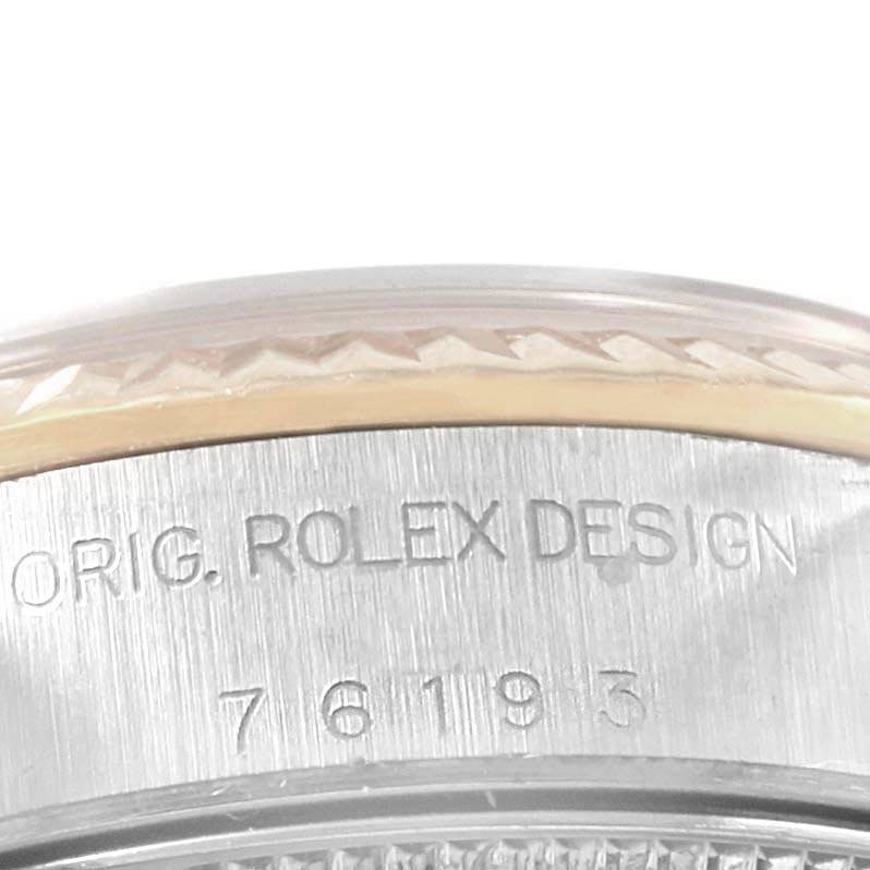 The image shows a close-up of the case side of a Rolex Oyster Perpetual 76193 Women
s Steel and Gold (two tone) Blue Dial 76193 Women
s Steel and Gold (two tone) Blue Dial watch, displaying its engraved model number and "ORIG. ROLEX DESIGN."