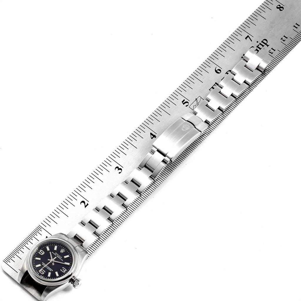 The image shows a Rolex Oyster Perpetual 176200 Women
s Stainless Steel Black Dial 176200 Women
s Stainless Steel Black Dial watch placed beside a ruler, displaying the watch face and metal bracelet.