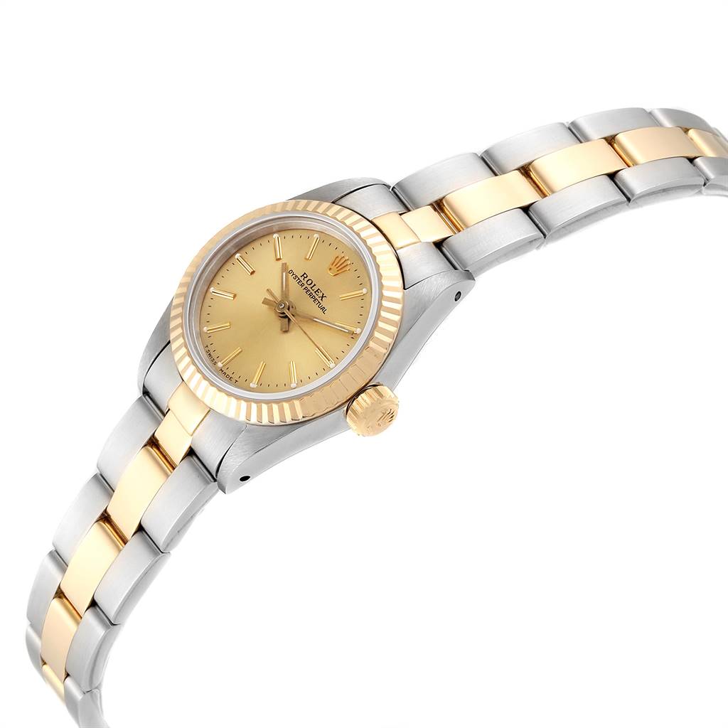 This Rolex Oyster Perpetual 67193 Women's Steel and Gold (two tone) Champagne Dial 67193 Women's Steel and Gold (two tone) Champagne Dial watch is shown at a slight angle, displaying its gold dial, fluted bezel, and two-tone bracelet.