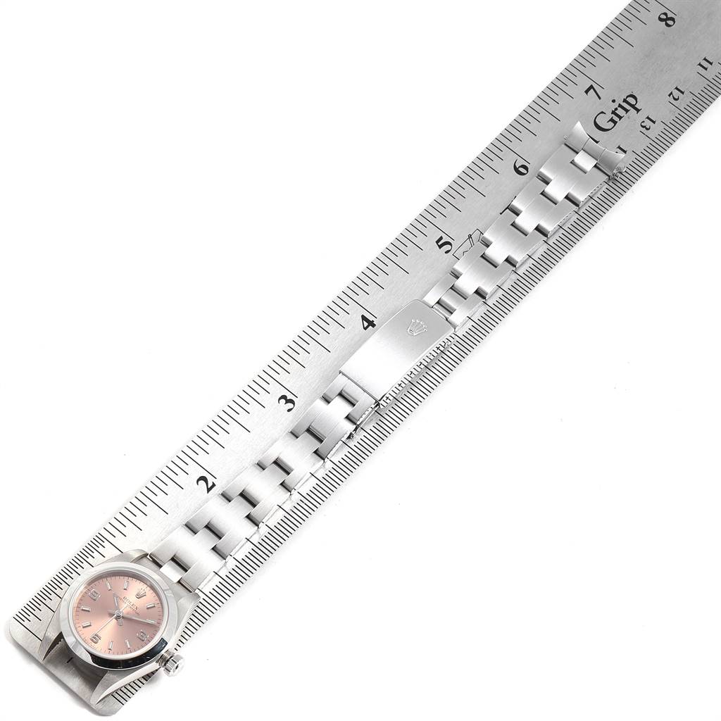 The image shows a Rolex Oyster Perpetual 76080 Women's Stainless Steel Pink Dial 76080 Women's Stainless Steel Pink Dial watch laid flat beside a ruler, showcasing the watch face, bracelet, and clasp.