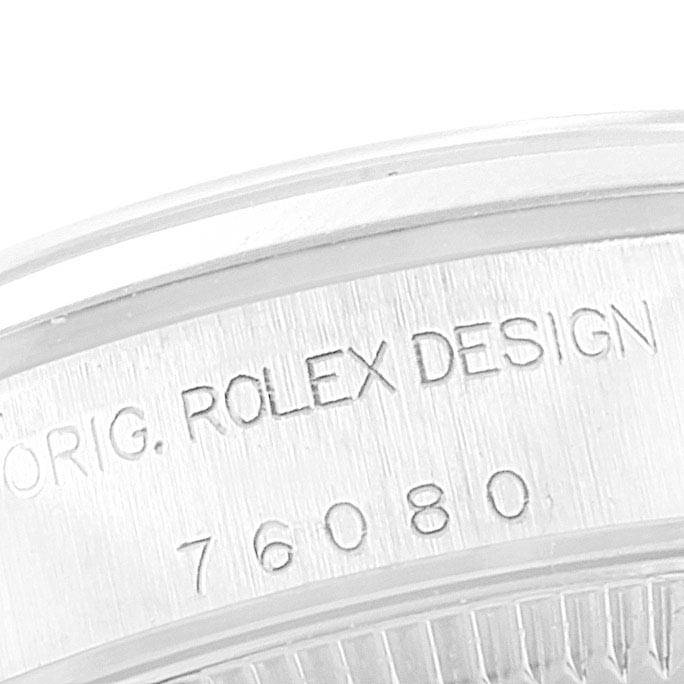 The image shows a close-up of the case back rim of the Rolex Oyster Perpetual 76080 Women
s Stainless Steel White Dial 76080 Women
s Stainless Steel White Dial watch, revealing engraving details.
