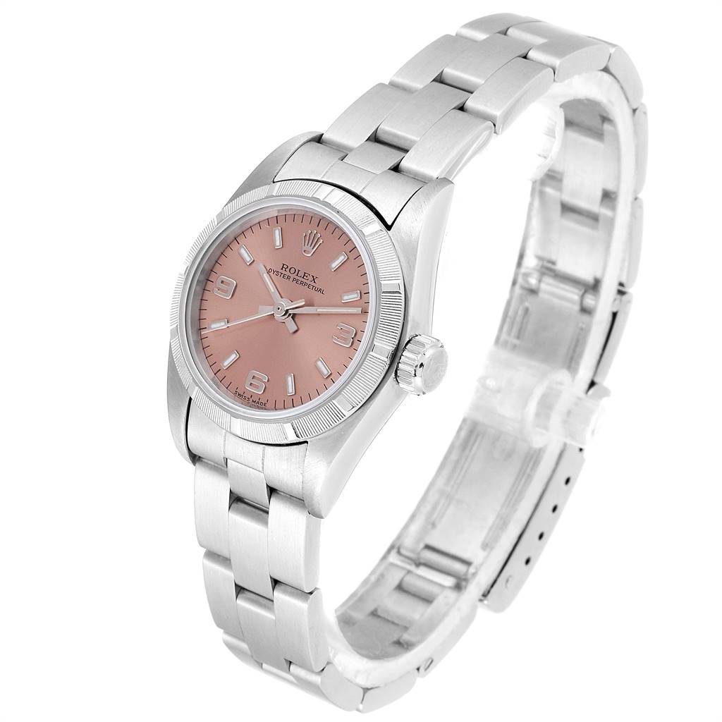 The image shows a side angle view of a Rolex Oyster Perpetual 67230 Women's Stainless Steel Pink Dial 67230 Women's Stainless Steel Pink Dial watch featuring its pink dial and stainless steel bracelet.