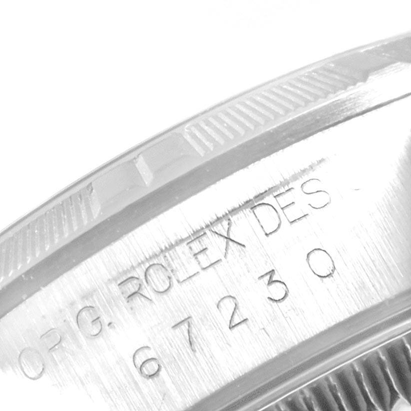 The image shows a macro shot of the case side, including engravings on the Oyster Perpetual model by Rolex.