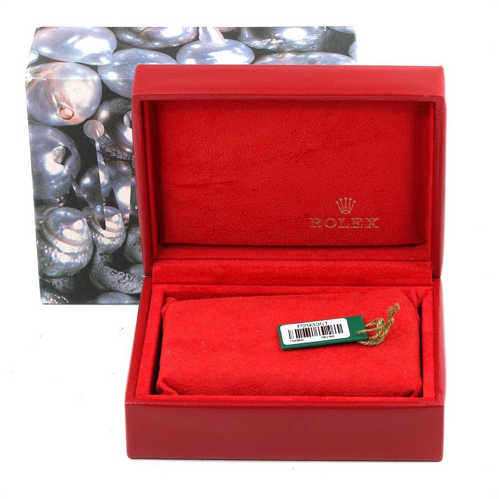 The image shows a Rolex Oyster Perpetual 76080 Women
s Stainless Steel Blue Dial 76080 Women
s Stainless Steel Blue Dial watch box and cushion from a front angle, with a tag placed on the cushion.