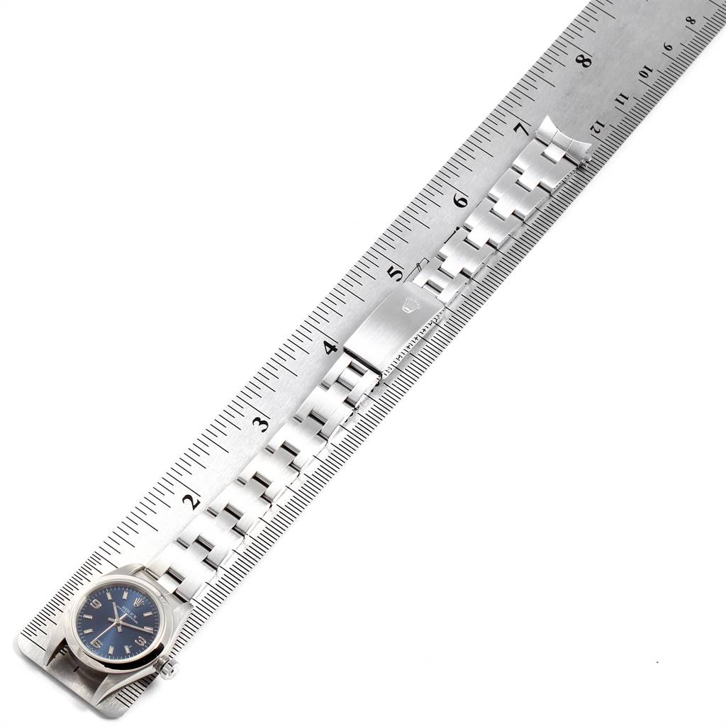 The image shows a Rolex Oyster Perpetual 76080 Women
s Stainless Steel Blue Dial 76080 Women
s Stainless Steel Blue Dial watch laid out straight alongside a ruler, displaying the face and full bracelet.