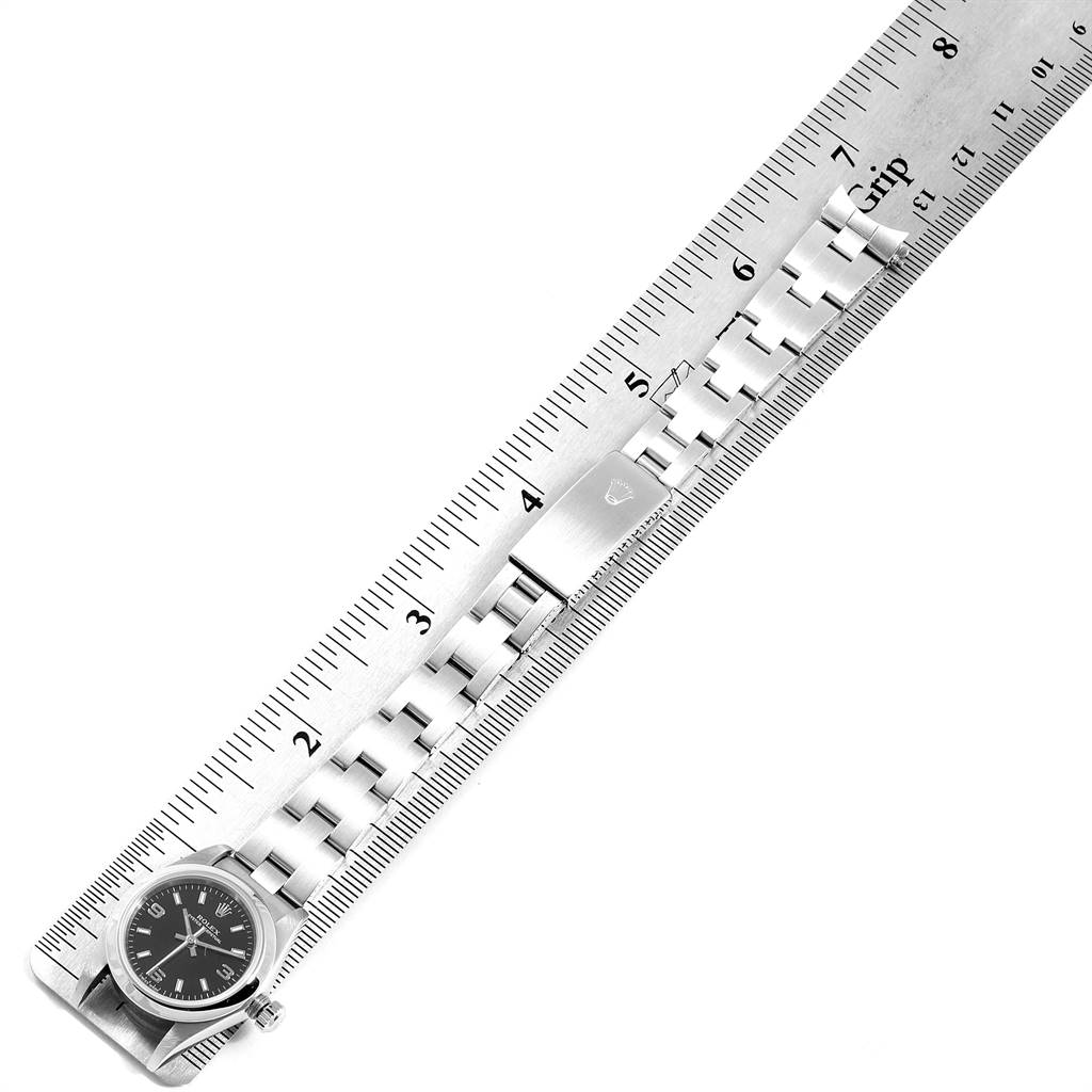 The image shows a horizontal view of the watch face and band of a Rolex Oyster Perpetual 76080 Women's Stainless Steel Black Dial 76080 Women's Stainless Steel Black Dial model against a measuring ruler.